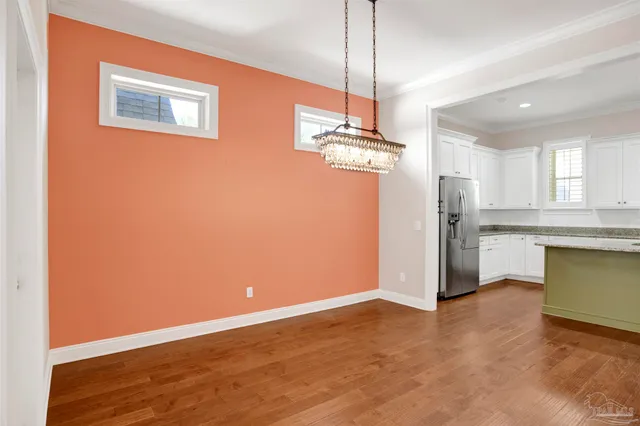 a view of a kitchen with a fridge wooden floor and a ceiling fan