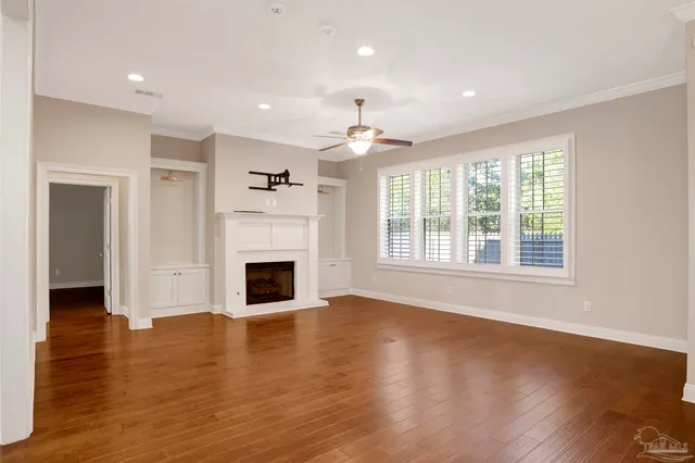a view of a livingroom with a fireplace wooden floor and window