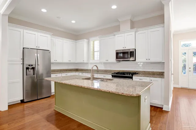 a kitchen with granite countertop a refrigerator stove and microwave