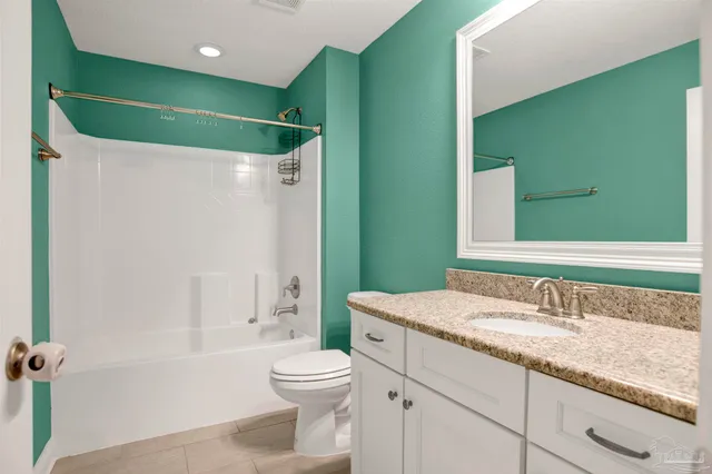 a bathroom with a granite countertop sink a toilet and a bathtub