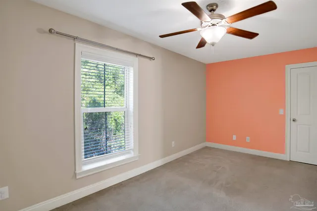 an empty room with a window and a fan