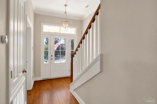 a view of a hallway with wooden floor and staircase