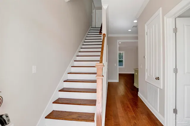 a view of a hallway with wooden floor and white walls