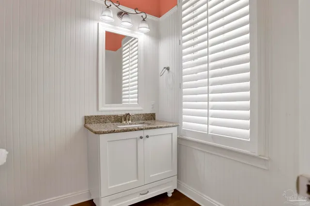 a bathroom with a granite countertop sink and a window