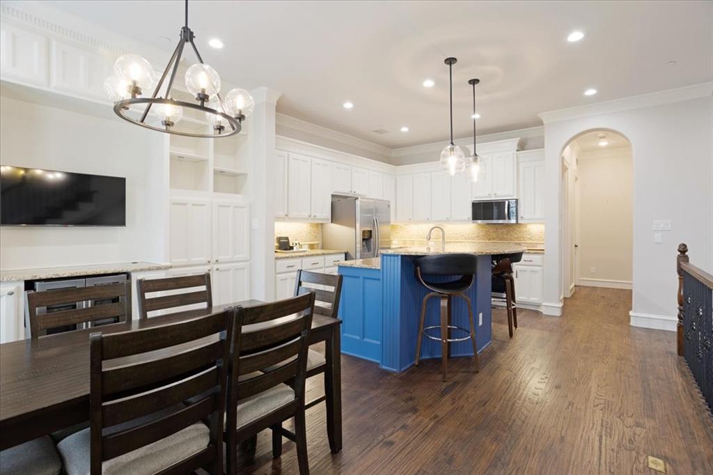 7940 Bishop Road Plano, TX 75024 - Photo 18 of 36 a kitchen with stainless steel appliances kitchen island granite countertop a table chairs and a refrigerator