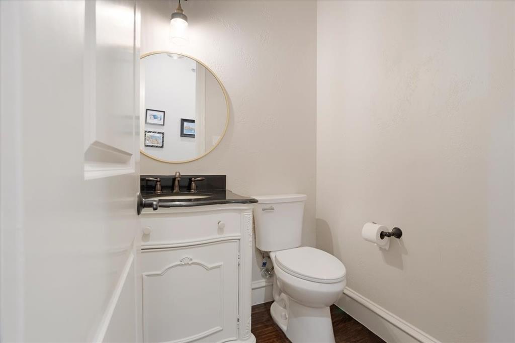7940 Bishop Road Plano, TX 75024 - Photo 24 of 36 a bathroom with a toilet a sink and mirror