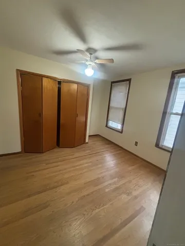 en empty room with windows and ceiling fan