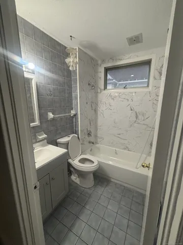 a bathroom with a bathtub shower sink mirror and toilet