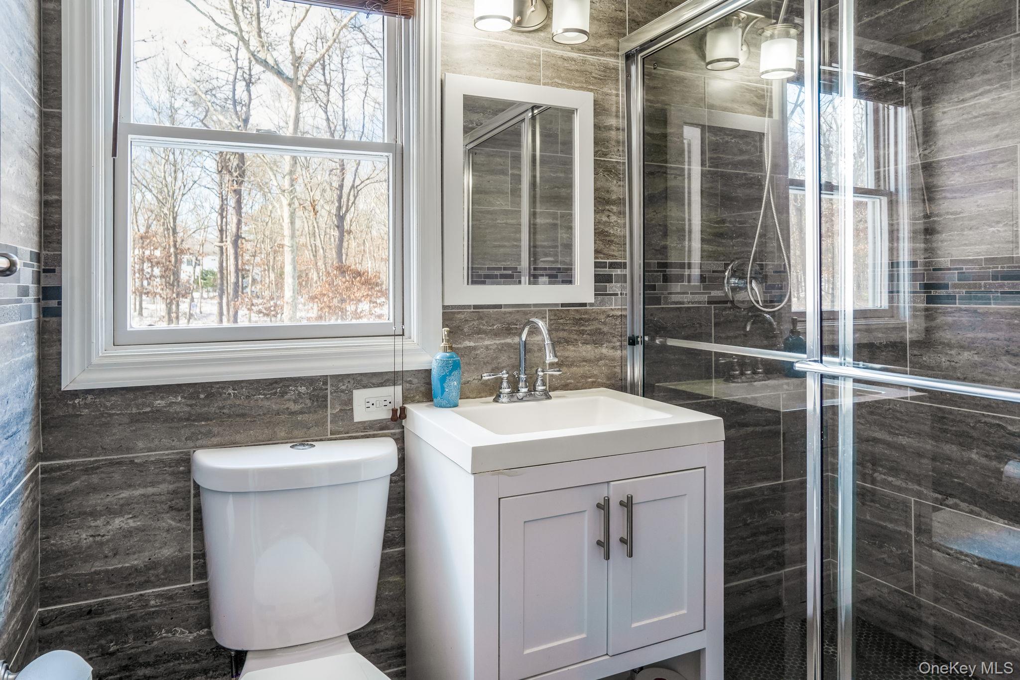 400 Eastport Manor Road Manorville, NY 11949 - Photo 12 of 29 a bathroom with a sink and a toilet