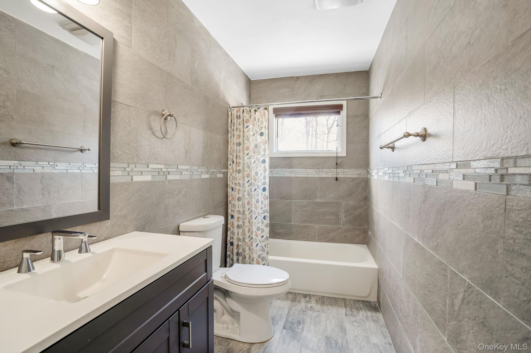 400 Eastport Manor Road Manorville, NY 11949 - Photo 22 of 29 a bathroom with a sink a toilet and shower