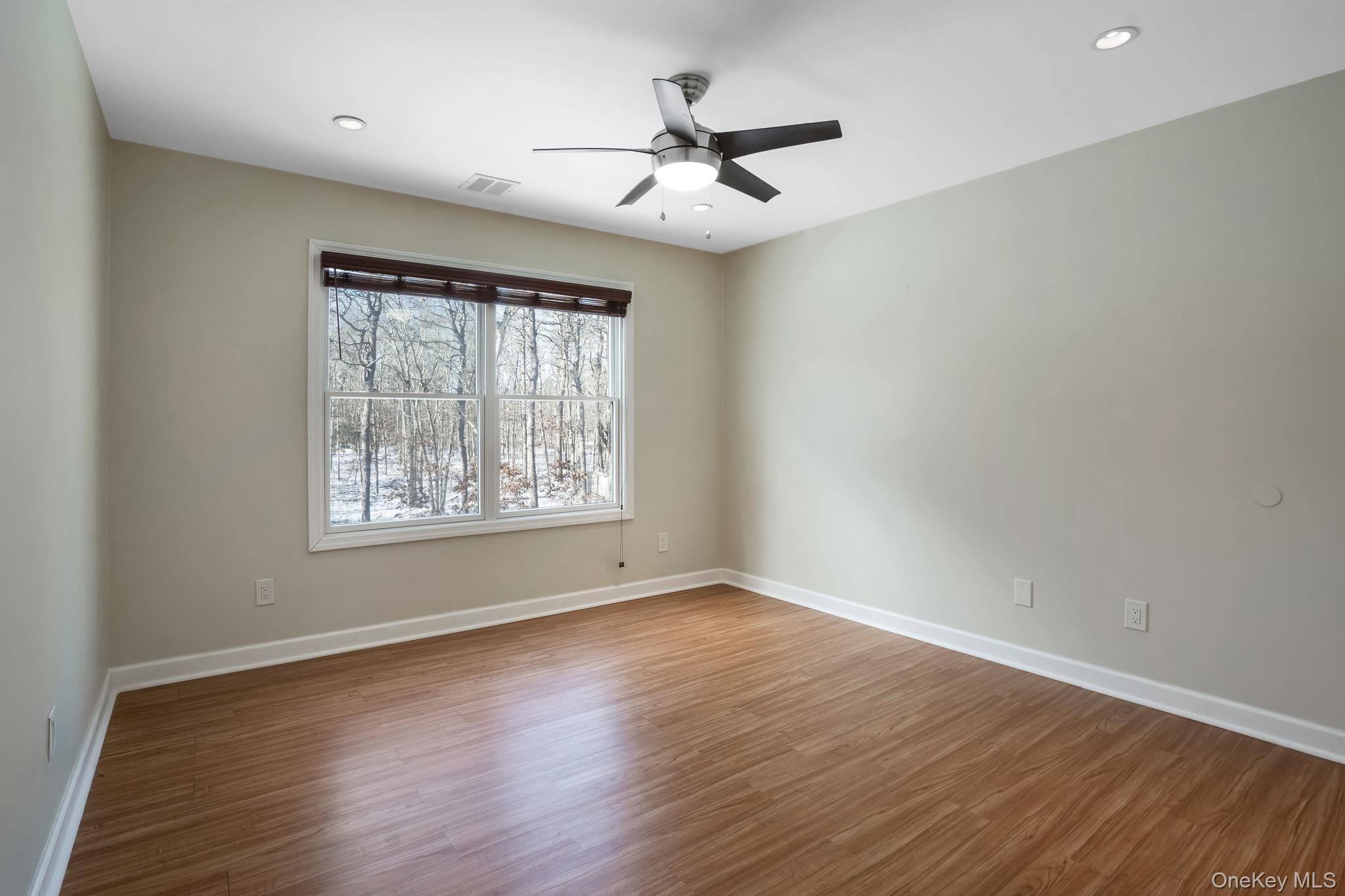 400 Eastport Manor Road Manorville, NY 11949 - Photo 25 of 29 wooden floor in an empty room with a window