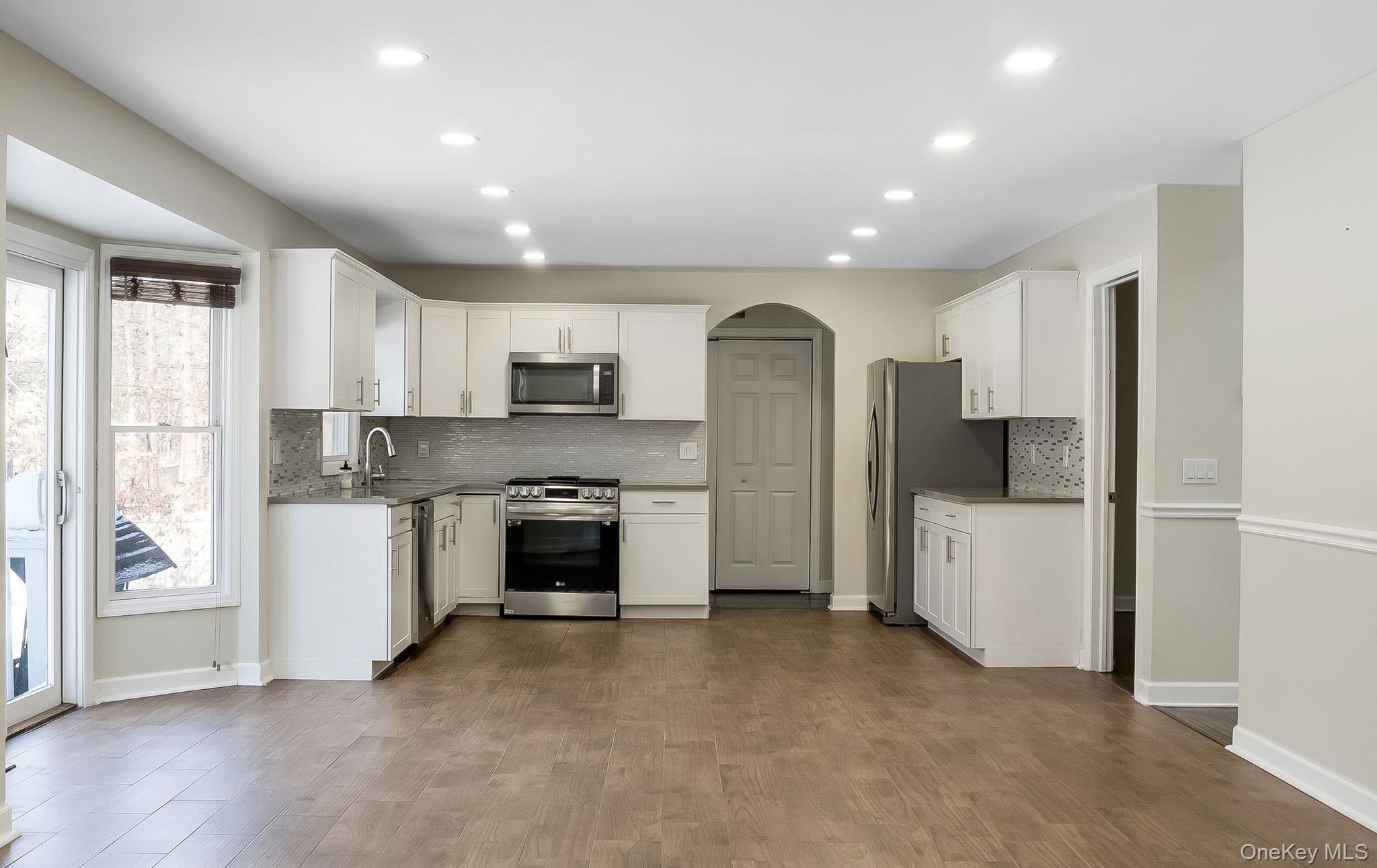 400 Eastport Manor Road Manorville, NY 11949 - Photo 8 of 29 a kitchen with refrigerator a sink and cabinets