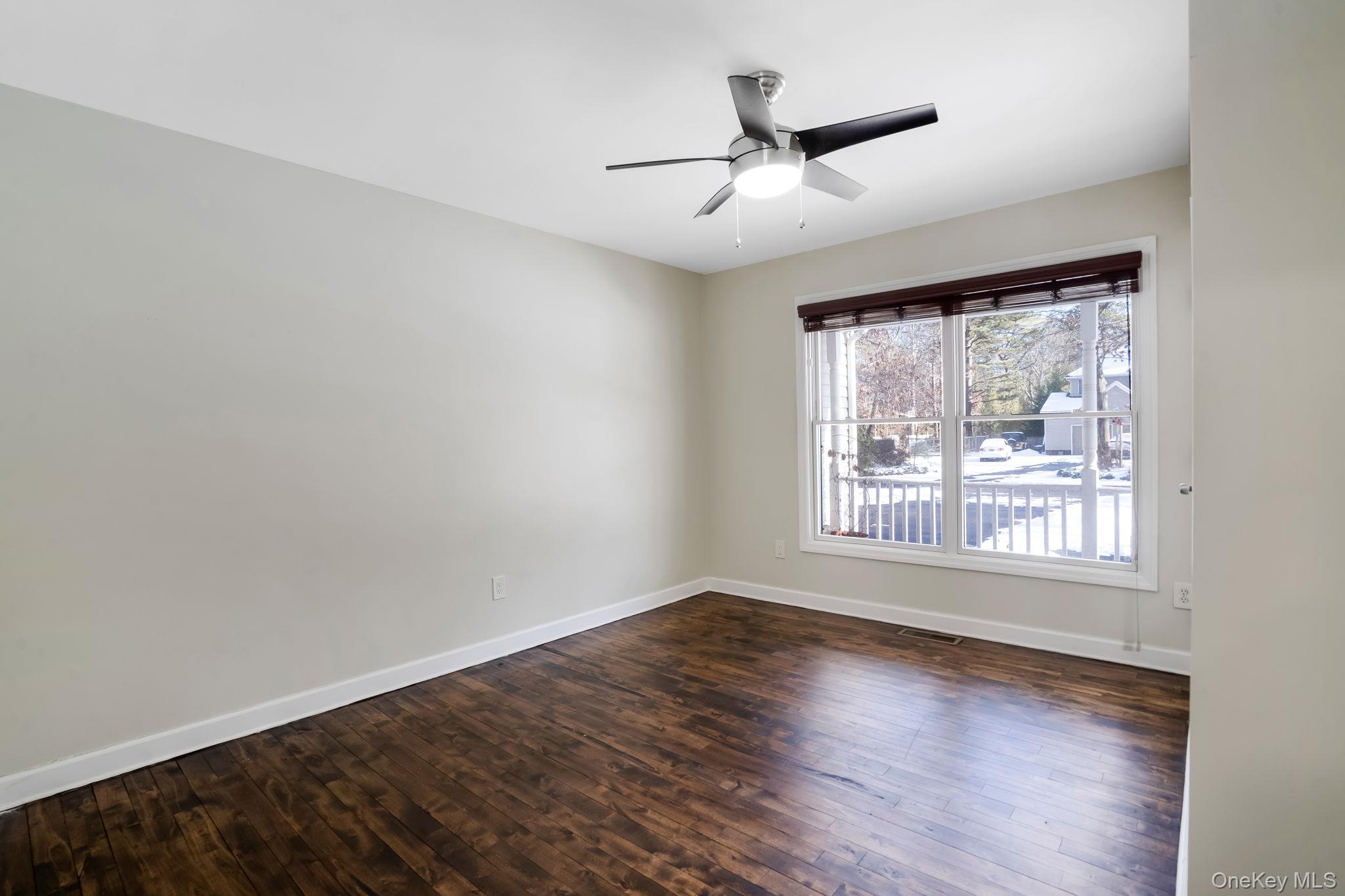 400 Eastport Manor Road Manorville, NY 11949 - Photo 10 of 29 a view of empty room with wooden floor and fan