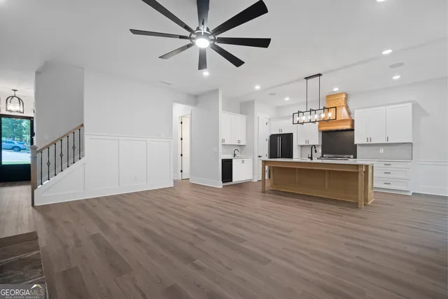 a view of an empty room with wooden floor fireplace and a window