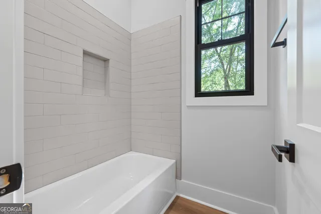a view of a room with wooden floor kitchen view and a chandelier