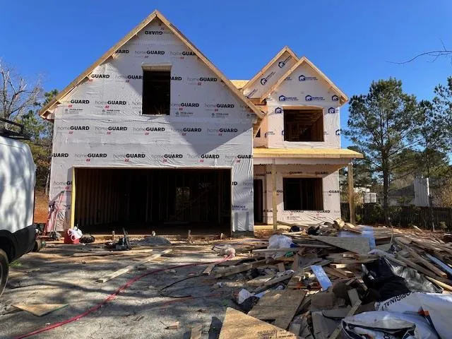 a view of a white house with a small yard and potted plants