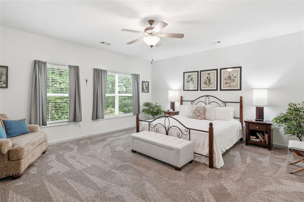 1114 Firethorne Pass Cumming, GA 30040 - Photo 17 of 43 a spacious bedroom with a bed and a couch