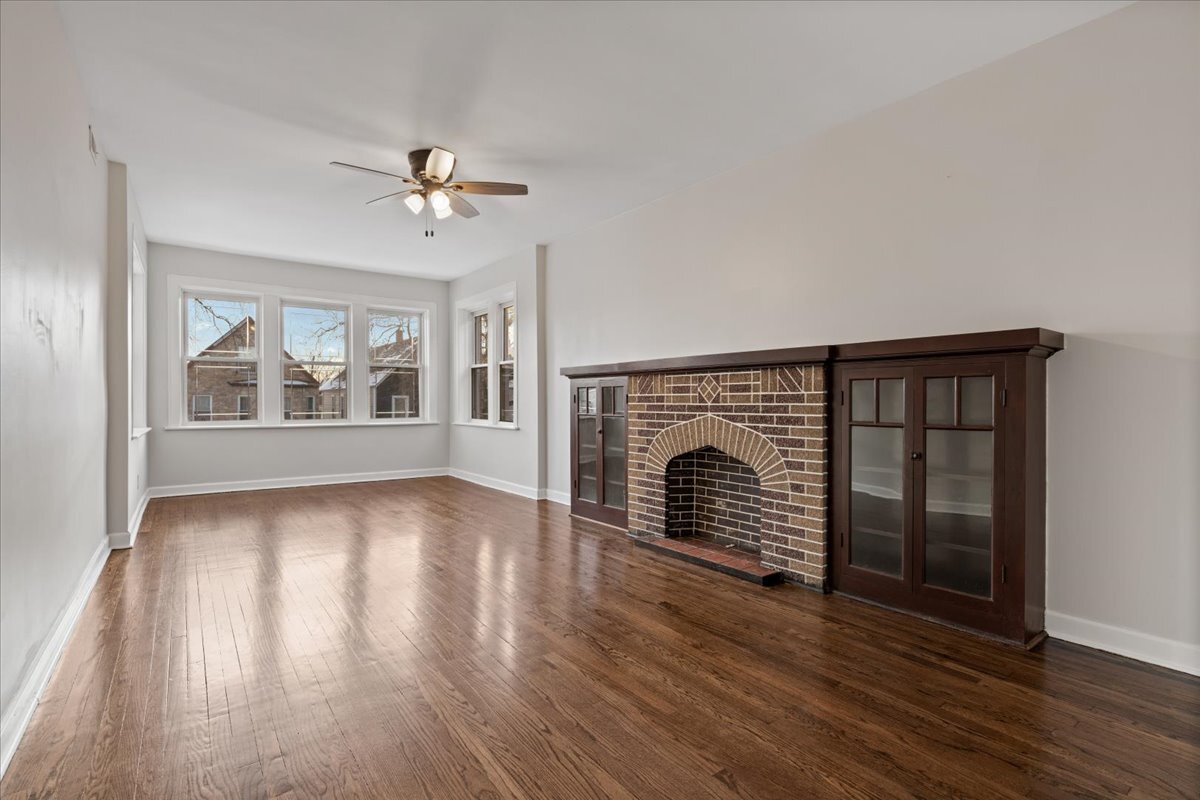 2338 North Avers Avenue, Unit 2 Chicago, IL 60647 - Photo 3 of 23 an empty room with wooden floor fireplace and windows