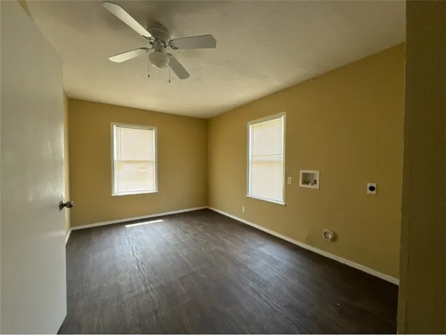 an empty room with a window and wooden floor