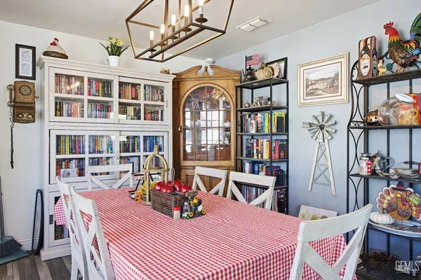 a kitchen with a stove a refrigerator and a table with wooden floor