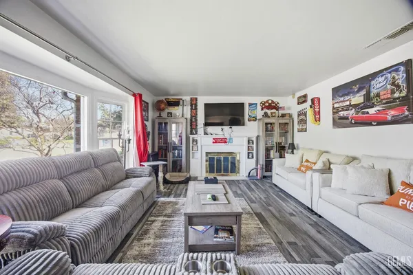 a living room with furniture a flat screen tv and a floor to ceiling window