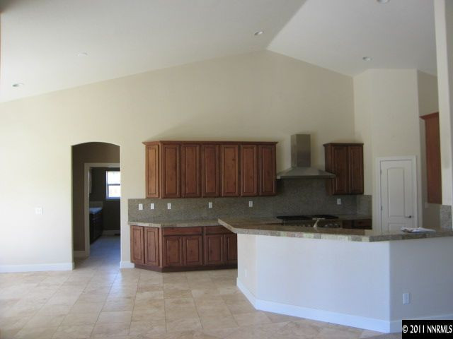 4805 Rancheria Road Fallon, NV 89406 - Photo 6 of 13 a kitchen with granite countertop a refrigerator and a stove top oven