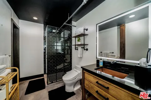a bathroom with a sink a toilet and shower