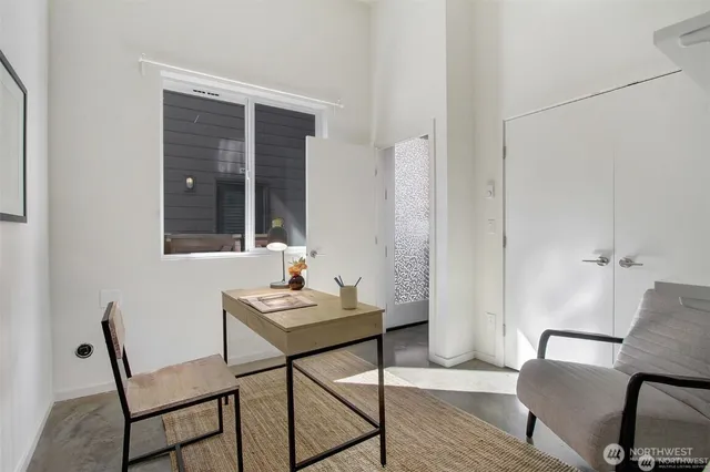 a view of a workspace room with wooden floor and furniture