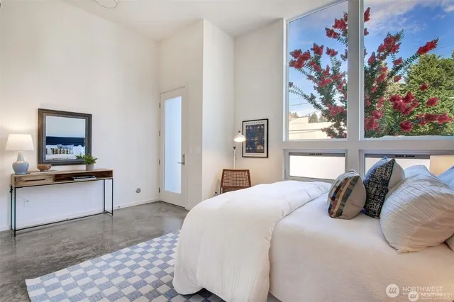 a bedroom with a bed and painting on the wall