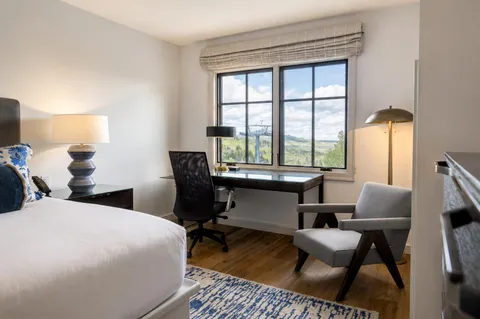 a bedroom with a bed and a large window