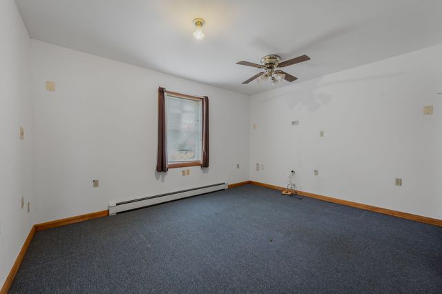 an empty room with a ceiling fan and a window