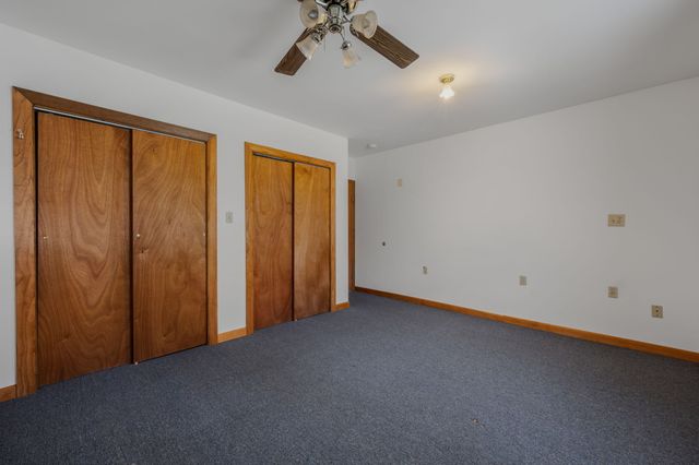 an empty room with a ceiling fan and window