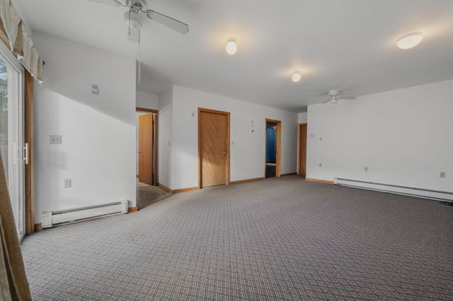 an empty room with closet and a ceiling fan