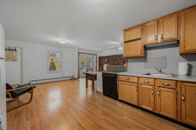 a kitchen with granite countertop wooden floors and wide window