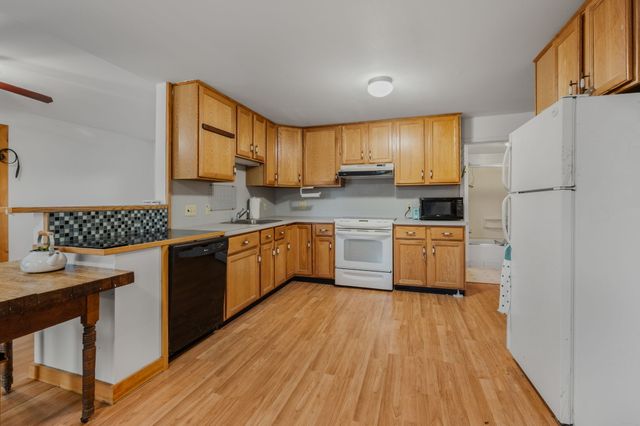 a kitchen with a sink a counter top space stainless steel appliances and cabinets