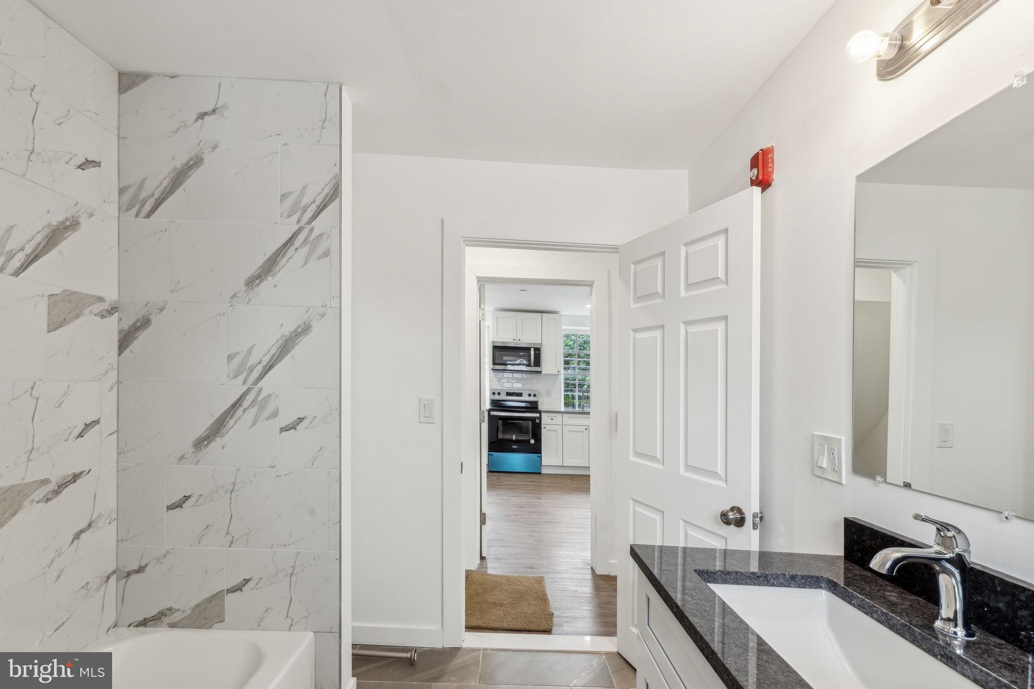 7041 Ridge Avenue Philadelphia, PA 19128 - Photo 15 of 22 a bathroom with a granite countertop sink a mirror and shower