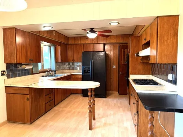 a kitchen with a sink refrigerator and cabinets