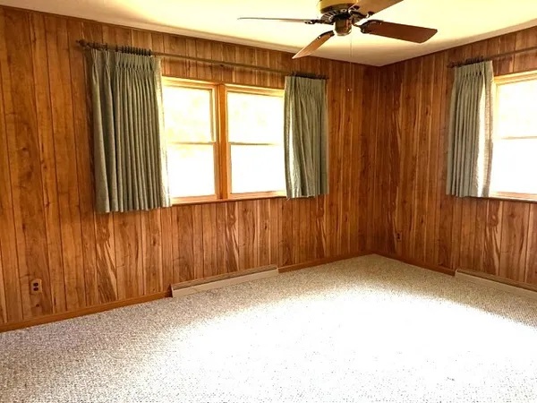 an empty room with a window and a ceiling fan