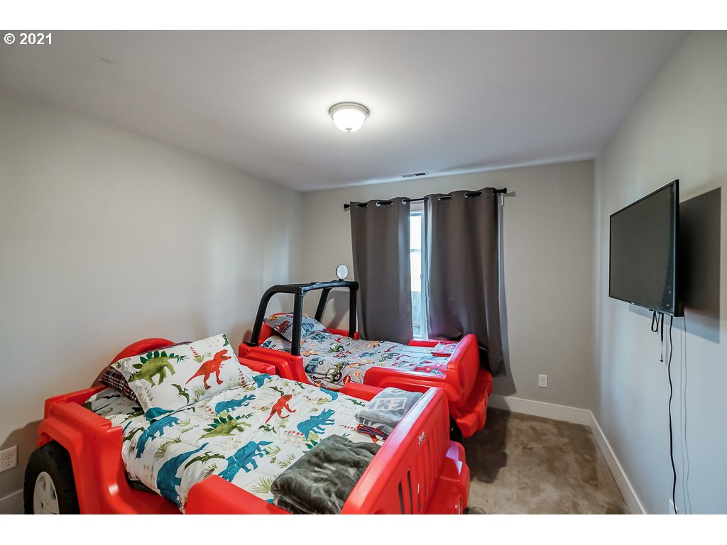806 Wassom Street Lebanon, OR 97355 - Photo 7 of 30 a bedroom with a bed and a flat screen tv