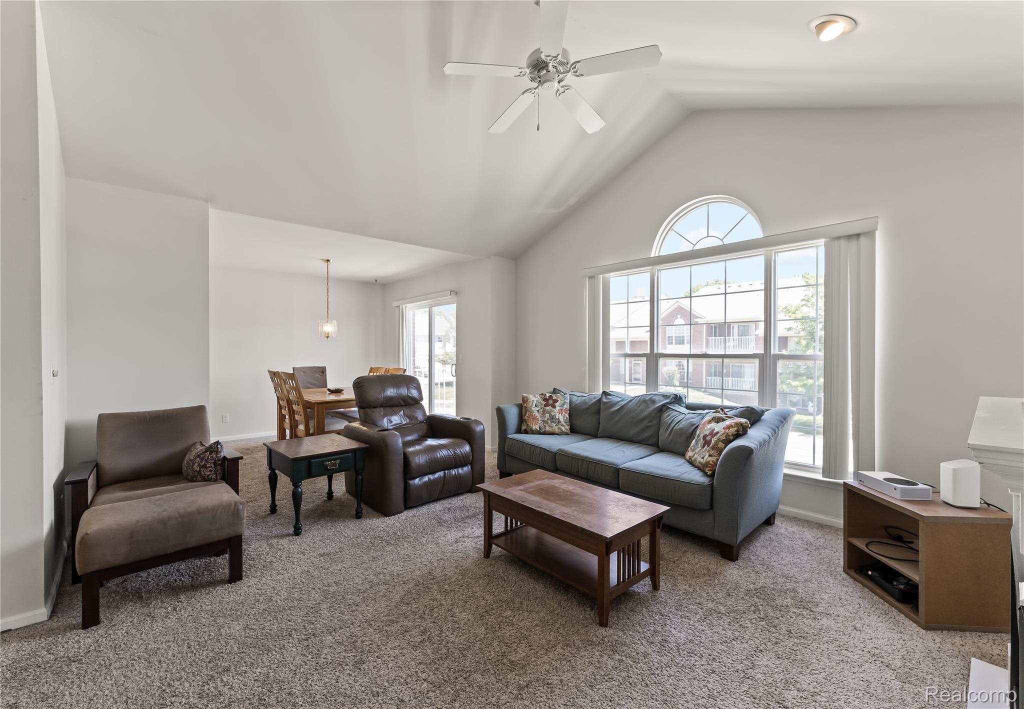 1861 Flagstone Circle Rochester, MI 48307 - Photo 5 of 21 Vaulted ceiling living area featuring a large arched window, ceiling fan, recessed lighting, and carpeting