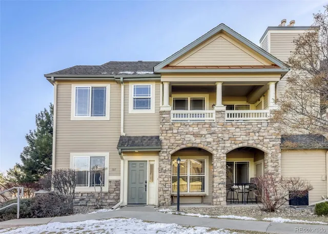 a front view of a house with a yard covered in snow