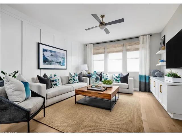 a living room with furniture ceiling fan and a flat screen tv
