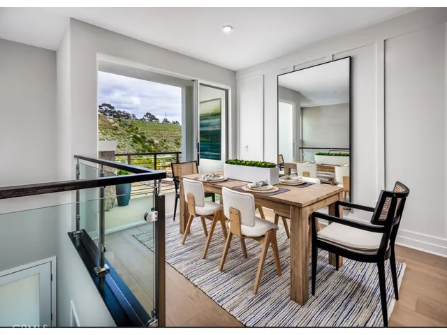 a view of a dining room and livingroom with furniture window and wooden floor