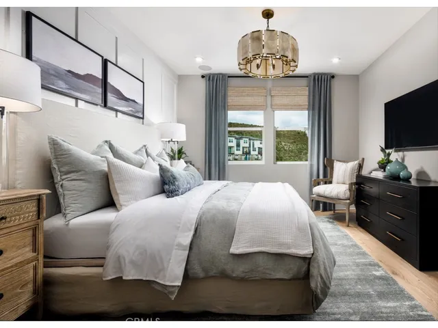 a bedroom with a large bed and a flat tv screen on dresser
