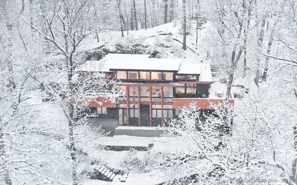 an aerial view of a house with balcony and trees all around