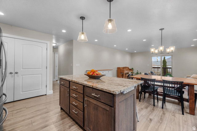1896 West 800 North Mapleton, UT 84663 - Photo 11 of 55 Kitchen with a center island, light stone counters, dark wood finish cabinets, and light wood-style flooring