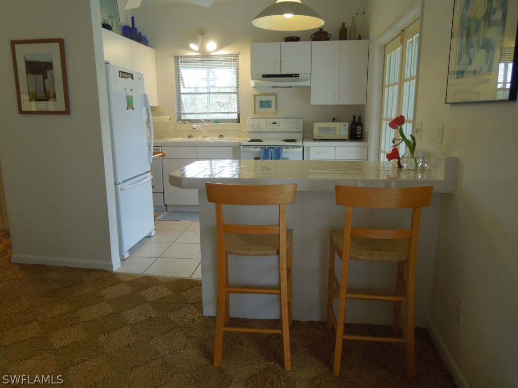 828 Rabbit Road Sanibel, FL 33957 - Photo 4 of 15 a kitchen with kitchen island a sink stainless steel appliances and cabinets