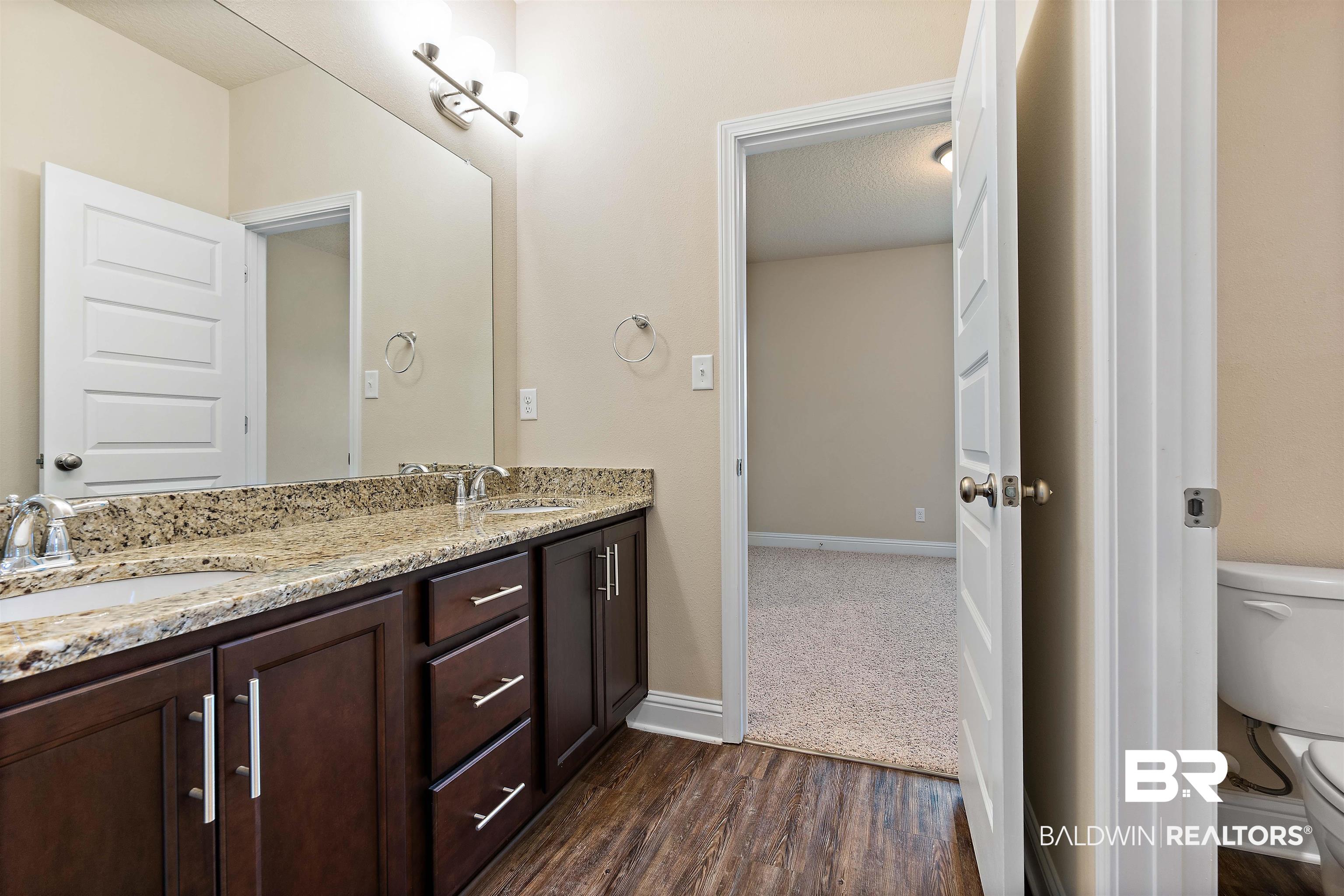 1864 Gwin Court Mobile, AL 36695 - Photo 27 of 37 Bathroom with toilet, double sink vanity, a textured ceiling, and wood-type flooring
