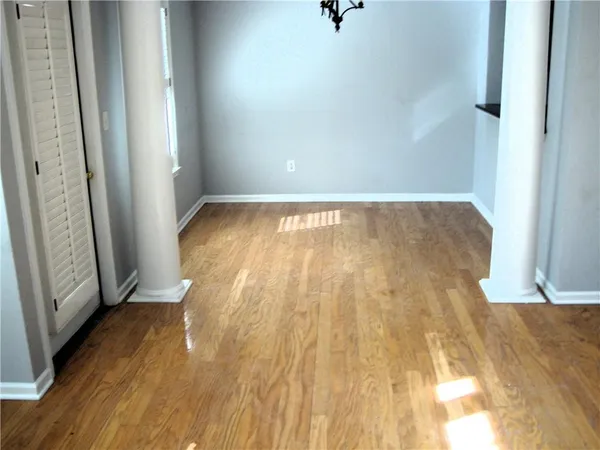 a view of empty room with wooden floor