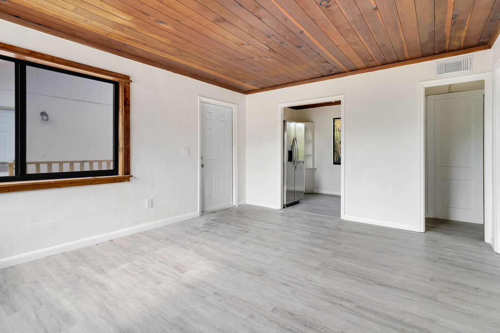 652 Hernando Street, Unit C Fort Pierce, FL 34949 - Photo 4 of 18 a view of an empty room with wooden floor and a window